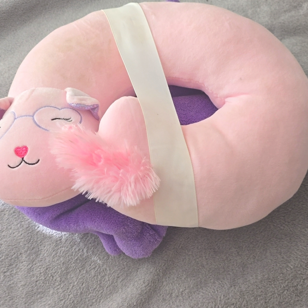 Pink neck pillow and purple blanket for traveling